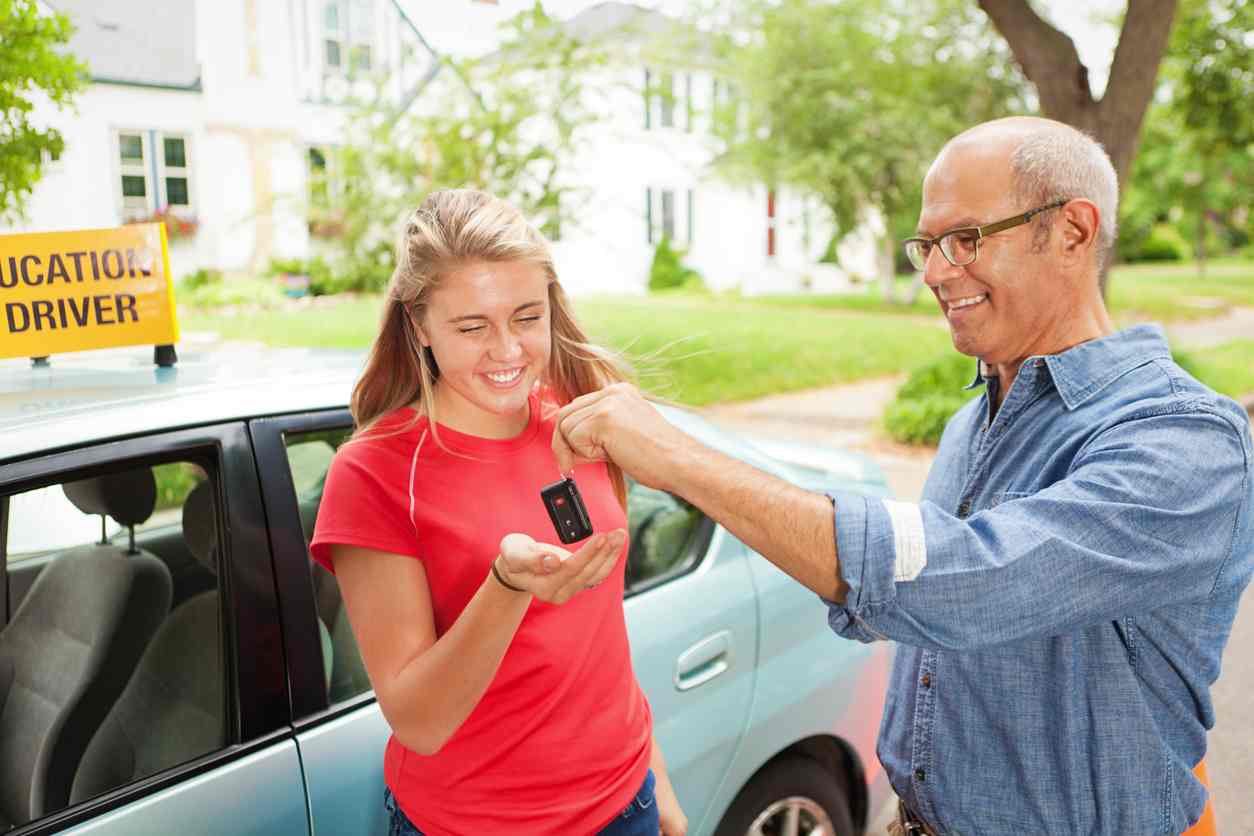 happy teen receiving car keyes fro m instructor